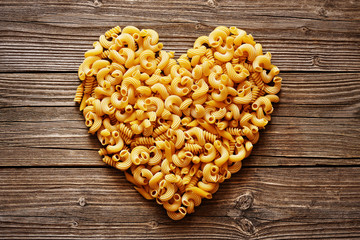Heart of pasta on a wood background