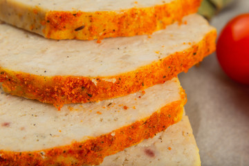 Meat product in the form of bread with spices and on baking paper.