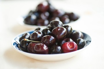 Dark red cherry on two plates.