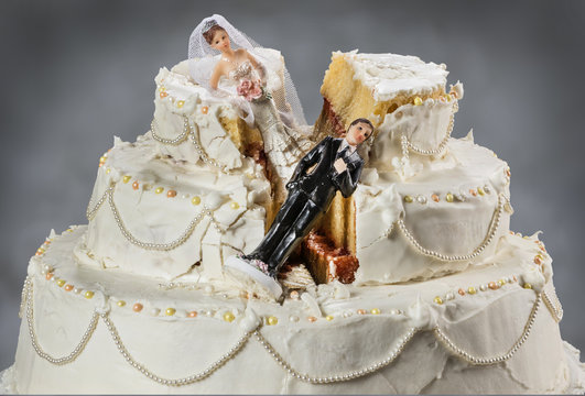 Bride and groom figurines collapsed at ruined wedding cake 