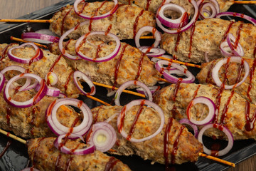Lulya-kebab. Shish kebab on a stick, minced meat. Traditional Caucasian dish. On a cutting board, with green salad, ketchup, spices