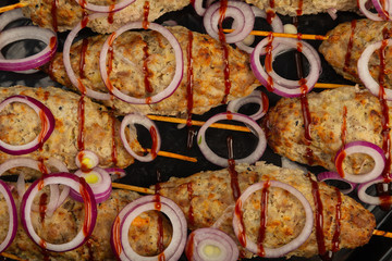 Lulya-kebab. Shish kebab on a stick, minced meat. Traditional Caucasian dish. On a cutting board, with green salad, ketchup, spices