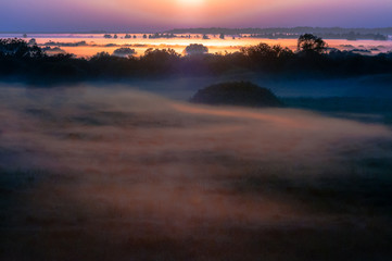 Natural Park of Biebrza Valley - sunrise in foggy morning over medow and pool