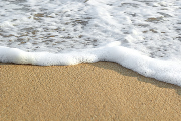 Soft wave of blue ocean on sandy beach. Background.