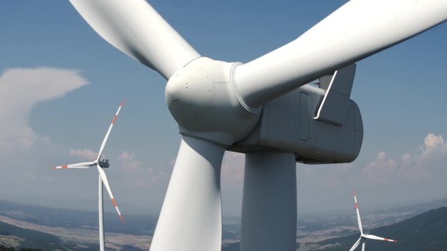 Aerial view of one windmill close to the turbine, blue sky in the background