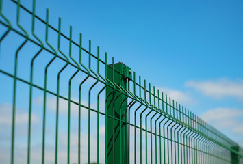 Steel grating fence made with wire on blue sky background. Sectional fencing installation