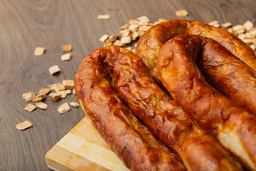 Homemade sausage on a wooden background with seasonings and sauce.