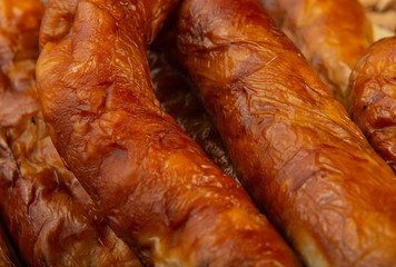 Homemade sausage on a wooden background with seasonings and sauce.