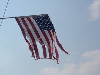 American Flag Torn Blue Sky Background