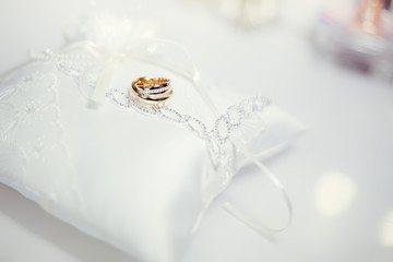 Wedding rings on white lace pillow