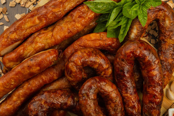 Homemade sausage on a wooden background with seasonings and sauce.