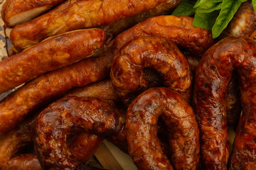 Homemade sausage on a wooden background with seasonings and sauce.