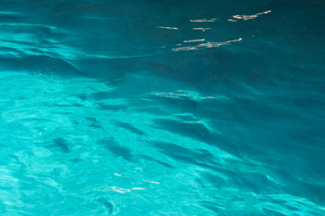 Blue colored background of rippling water surface, calm ocean. Sea wallpaper pattern texture.