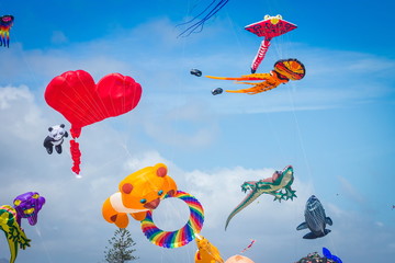 Brightly colored kites flying against a summer blue sky