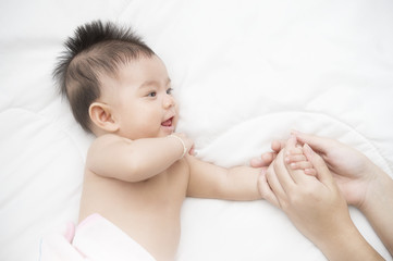 Smiling baby girl lying on a bed