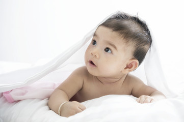 Smiling baby girl lying on a bed