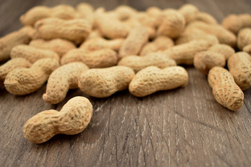 Peanuts on a wooden background stock photo images. Pile of peanuts with nutshell. Roasted Peanuts on a natural background