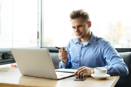 Young man drawing template for the web site associated with digital marketing, current trends and tendencies of UX / UI design. Businessman who rules his company remotely, like a freelancer