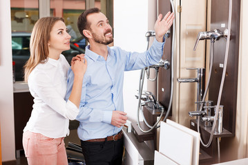 Couple choosing new shower mixer in store