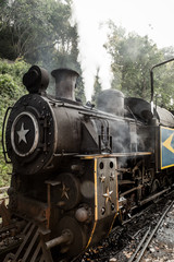 Obraz na płótnie Canvas Old steam locomotive train and smoke, Nilgiri Mountain Railway, Ooty, Tamil Nadu, India