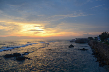 Galle Fort, Sri Lanka - May 04, 2018: View of the stone wall of the city and the ocean at sunset. South-western coast of Sri Lanka