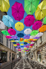 Fototapeta na wymiar Multicoloured umbrellas as street art in Arles, France