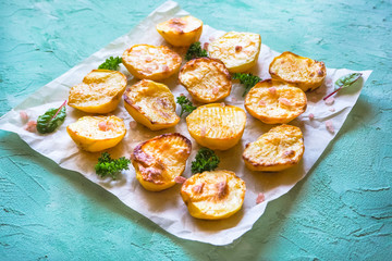 Appetizing baked potatoes halves on parchment.