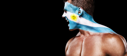 Soccer or football fan with bodyart on face with agression - flag of Argentina.