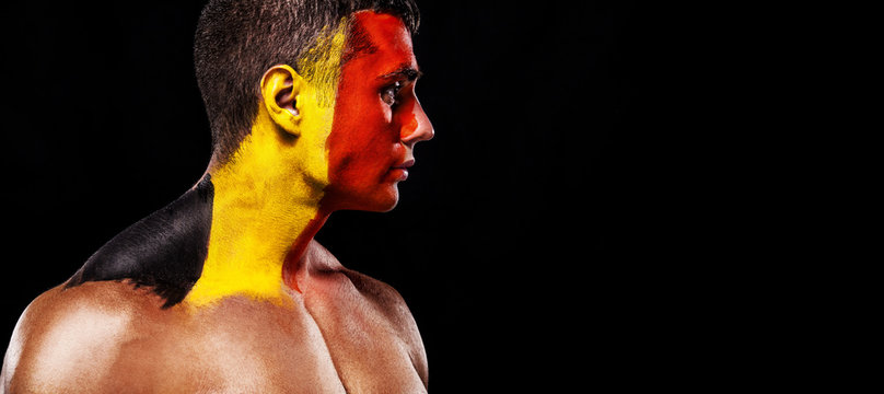 Soccer or football fan with bodyart on face with agression - flag of Belgium.