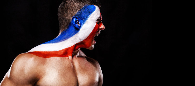 Soccer or football fan with bodyart on face with agression - flag of France.
