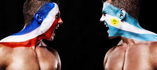 Soccer or football fan with bodyart on face with agression - flag of France vs Argentina.