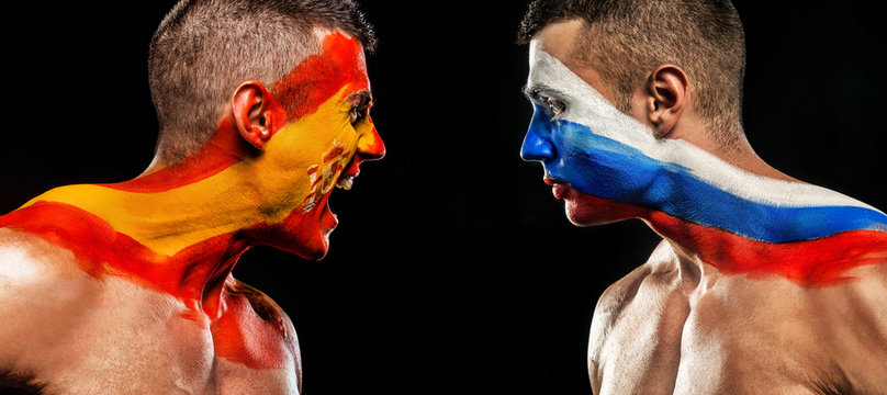 Soccer or football fan with bodyart on face with agression - flag of Spain vs Russia.