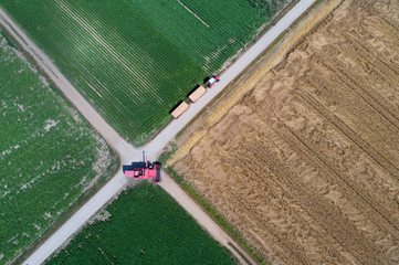 Combine harvester and tractor driving in fields