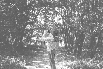 Girl using binoculars in the forest