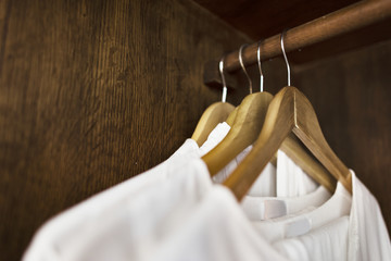 Fototapeta na wymiar White clothes hanging in a wardrobe