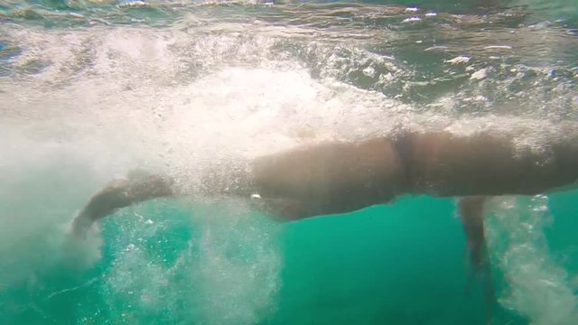 the view under water: a man is swimming freestyle