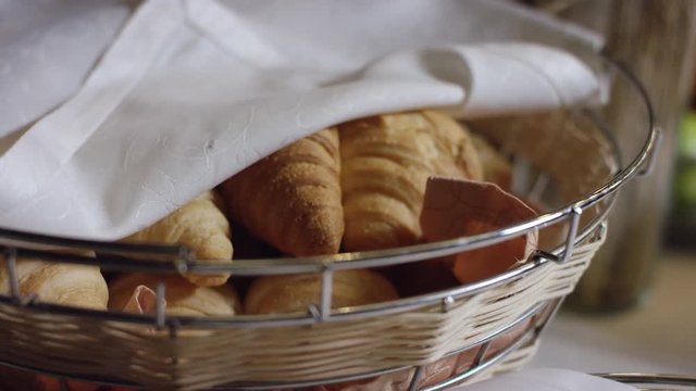fresh croissants in the basket on the served table in buffet in the new hotel