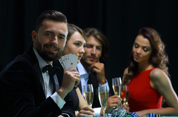 Poker player to four aces over dark background