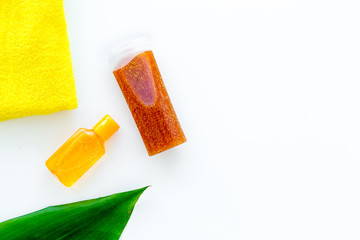 Sun protection products. Bottles with cream or lotion near towel and palm leaves on white background top view copy space