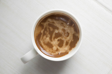 Coffee is in the white mug on floor background