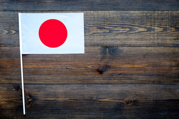 Japanese flag concept. small flag on dark wooden background top view copy space