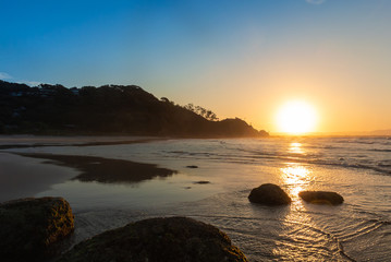 Sunset on the beach with big rocks in Byron Bay, Australia