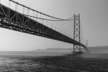 Black and white tone with artificial grain of Akashi Kaikyo bridge, world longest suspension metal bridge in Kobe, Japan