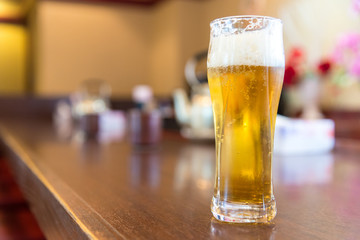 Full cold beer in a glass at bar counter