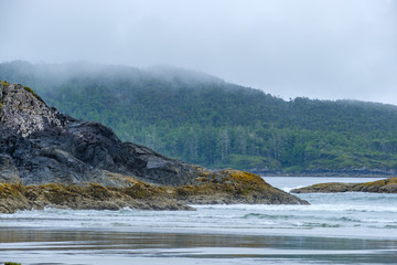 wave pounding the shore rocks on the wild pacific island on a overcast day