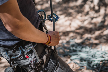 Rock climber belaying close up whit an atc and rope