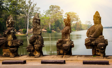 Stone statues of gods and demons on bridge to south gate in the complex of Angkor Thom, Siem Reap,...
