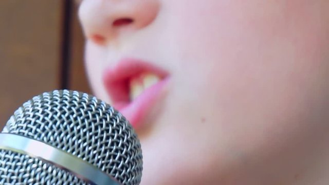 child's mouth sings into the microphone.close-up