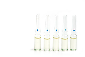 Five glass ampoules with liquid on the old background