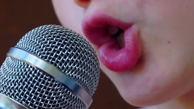 child's mouth sings into the microphone.close-up
